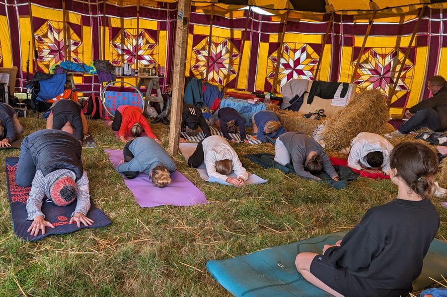 Participants taking part in outdoor yoga overlooking the coast.